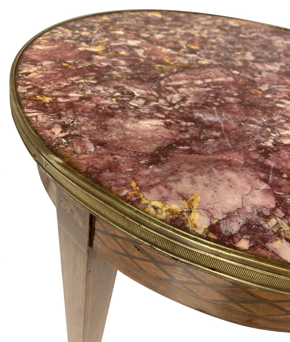 A nineteenth-century French circular gueridon table with a mottled marble top, brass rim, diamond parquetry frieze, and tapered legs. View IV