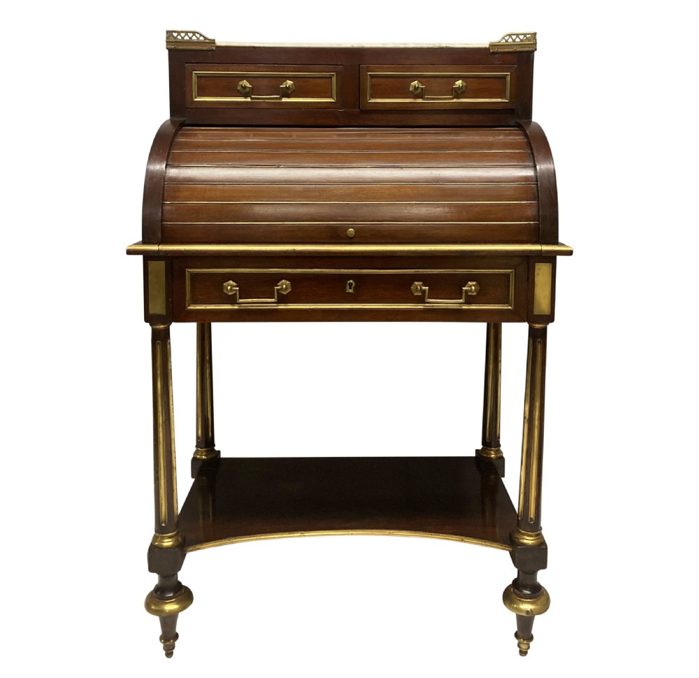 A small Directoire style mahogany cylinder desk with brass inlay trim, a marble top framed by a pierced brass gallery, slatted roll-top cylinder, drawer, and tapered legs. View II