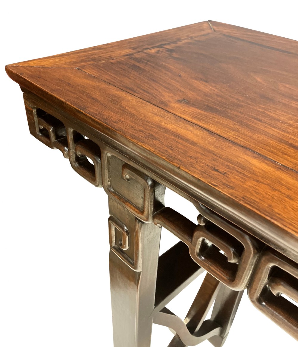 A dark brown Chinese Qing dynasty console table featuring an openwork geometric fretwork apron and curved side stretchers. View VII
