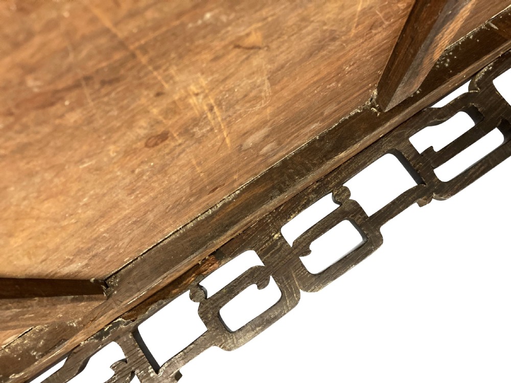 A dark brown Chinese Qing dynasty console table featuring an openwork geometric fretwork apron and curved side stretchers. View X