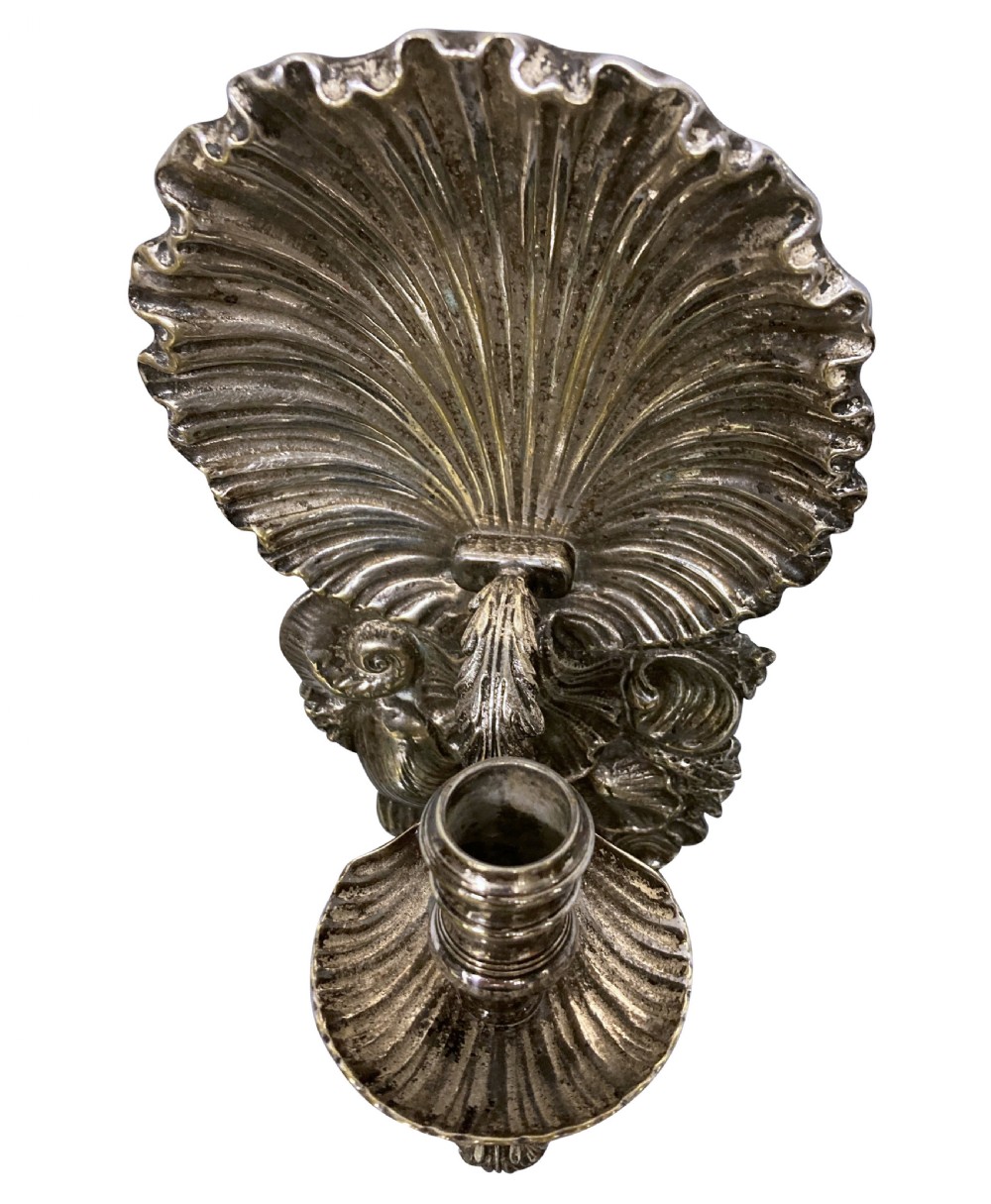 A pair of cast silver grotto style candle sconces featuring detailed scallop shell backplates and scrolling branches. View V