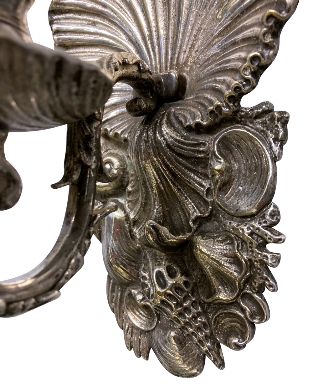 A pair of cast silver grotto style candle sconces featuring detailed scallop shell backplates and scrolling branches. View VI