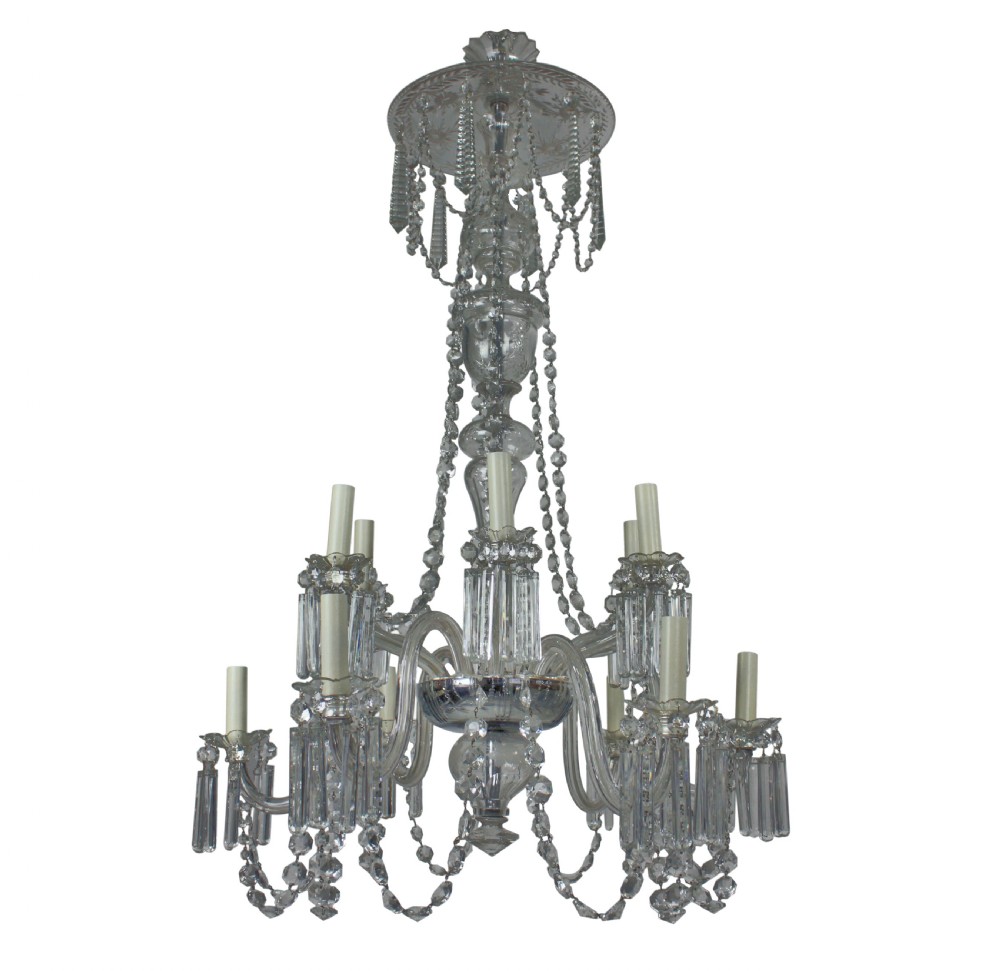 A nineteenth-century English cut glass chandelier featuring twelve candle-style lights, glass swags, hung faceted droplets, and a central baluster stem.