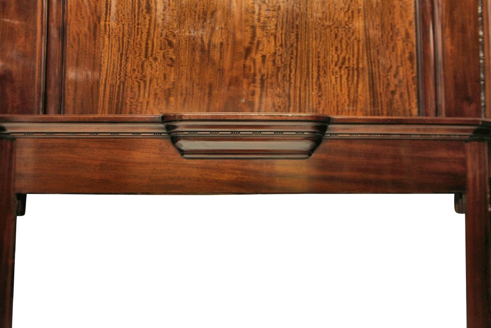 A large dark polished mahogany chimneypiece featuring an integrated panelled overmantel and architectural stepped mouldings. View II