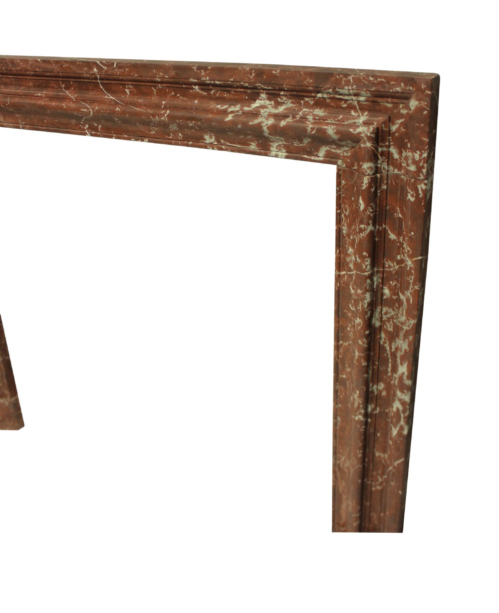 A large dark polished mahogany chimneypiece featuring an integrated panelled overmantel and architectural stepped mouldings. View XI