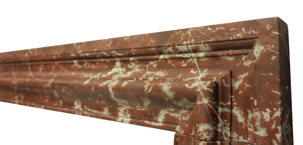 A large dark polished mahogany chimneypiece featuring an integrated panelled overmantel and architectural stepped mouldings. View XII