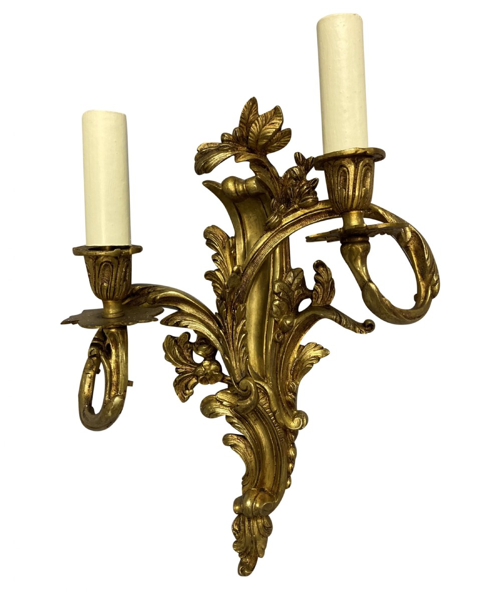 A pair of French Louis XV style gilt bronze two-light wall sconces featuring ornate asymmetrical acanthus foliage and candle holders. View II