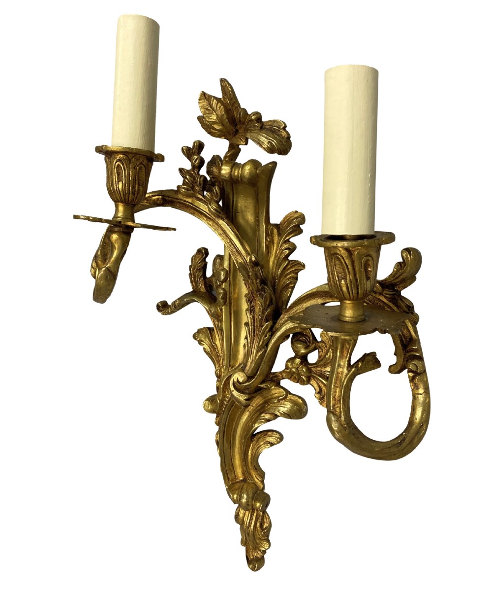 A pair of French Louis XV style gilt bronze two-light wall sconces featuring ornate asymmetrical acanthus foliage and candle holders. View IV