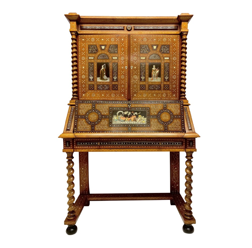An ornate 19th-century Moorish Revival walnut cabinet secretaire on stand featuring intricate bone inlay and barley-twist legs.