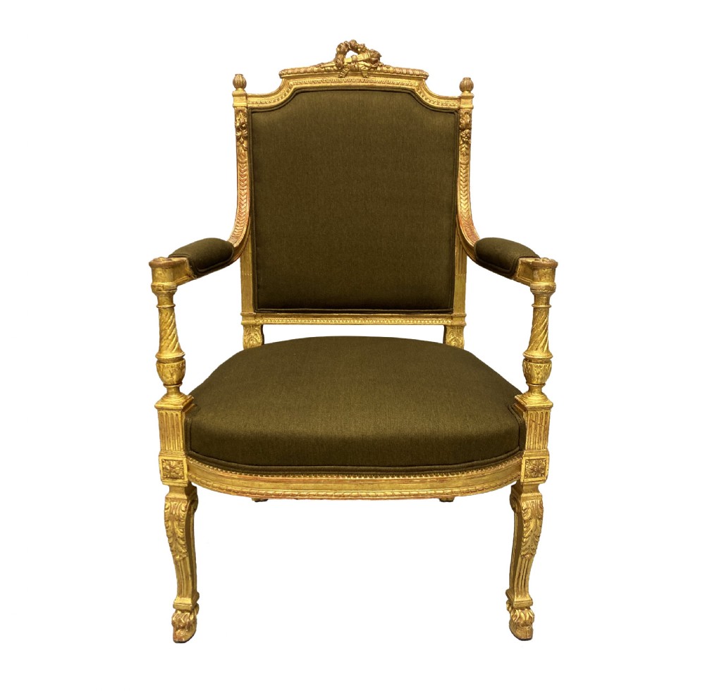 A Louis XIV style giltwood armchair featuring a gold leaf carved frame, turned arm supports, and dark olive green fabric upholstery.