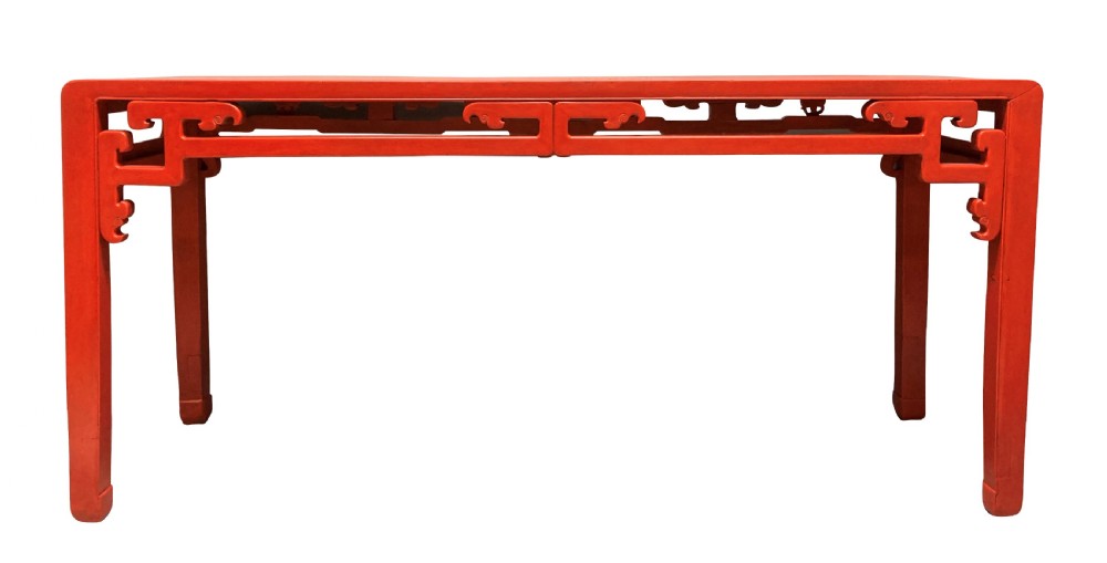 A 19th-century Chinese red lacquered console table featuring a long rectangular top and carved scroll aprons along the frame. View V