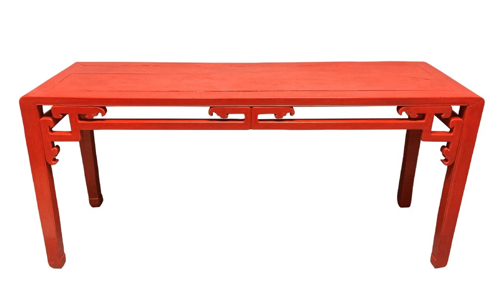 A 19th-century Chinese red lacquered console table featuring a long rectangular top and carved scroll aprons along the frame. View VI