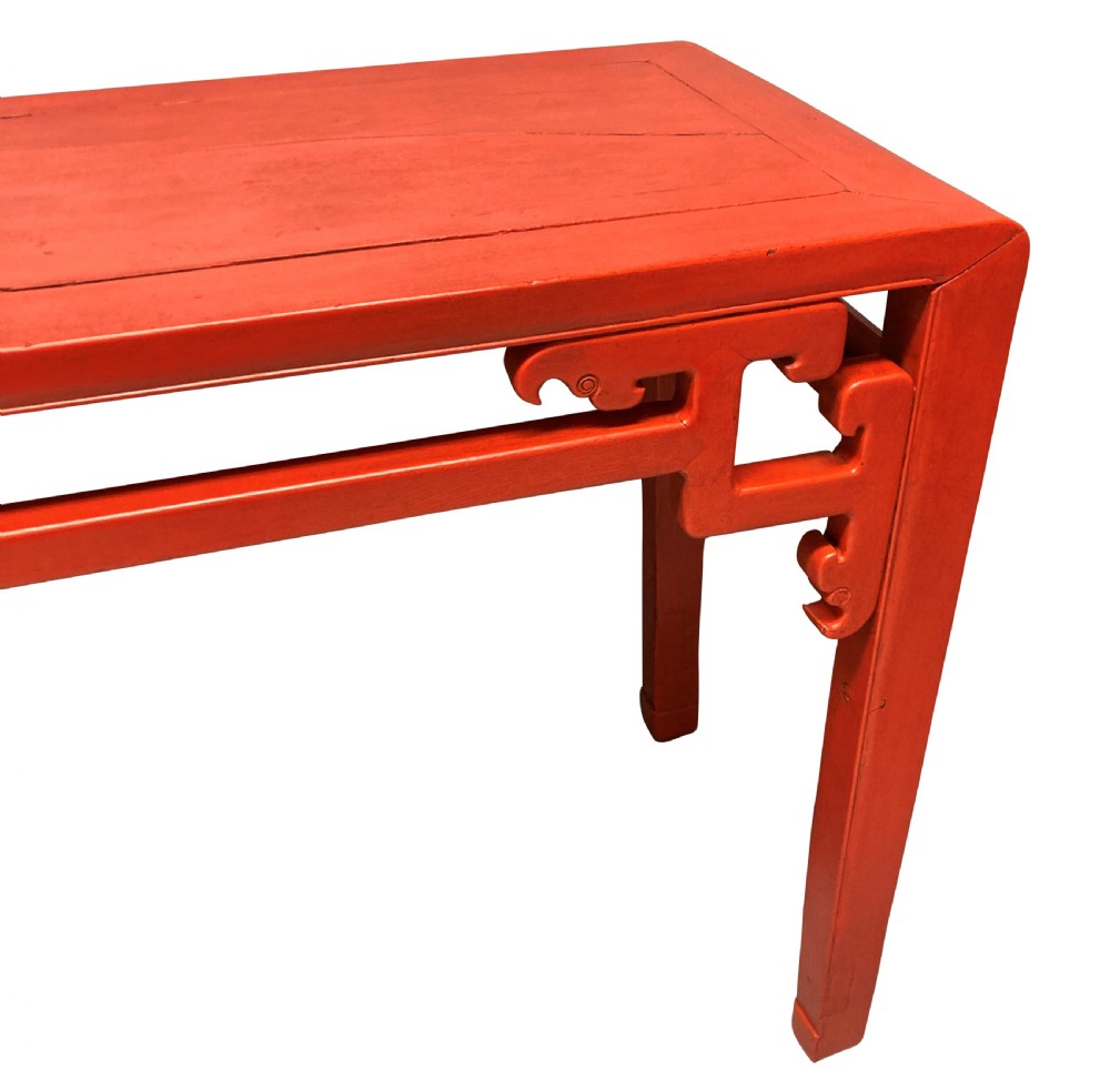 A 19th-century Chinese red lacquered console table featuring a long rectangular top and carved scroll aprons along the frame. View VII
