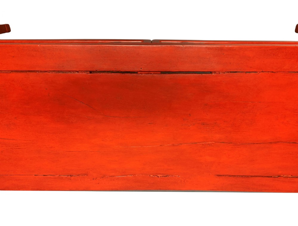 A 19th-century Chinese red lacquered console table featuring a long rectangular top and carved scroll aprons along the frame. View VIII