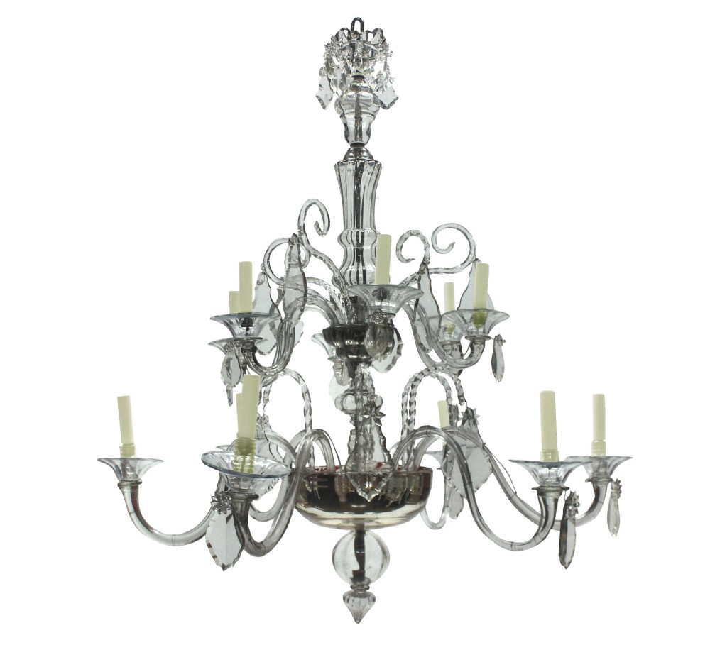 A Venetian blown clear glass twelve-branch chandelier featuring scrolled glass arms, candle sleeves, decorative glass drip pans, and crystal drops.