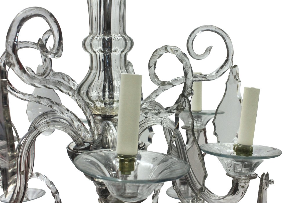 A Venetian blown clear glass twelve-branch chandelier featuring scrolled glass arms, candle sleeves, decorative glass drip pans, and crystal drops. View V