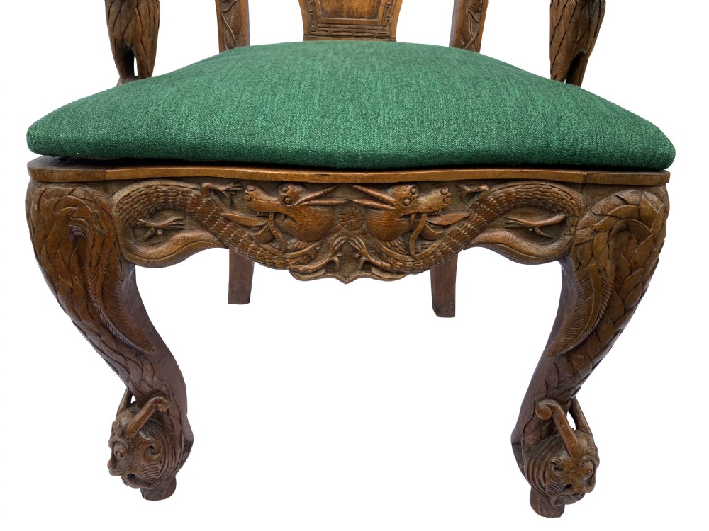 A pair of 19th-century carved teak Chinese armchairs featuring dragon motif armrests, detailed back splats, cabriole legs, and green upholstered seat cushions. View V