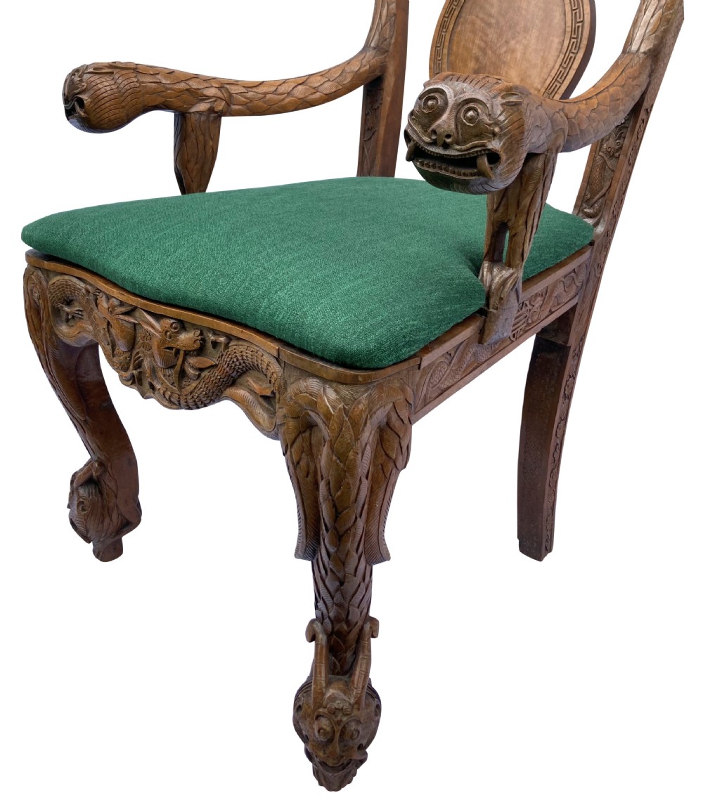 A pair of 19th-century carved teak Chinese armchairs featuring dragon motif armrests, detailed back splats, cabriole legs, and green upholstered seat cushions. View VII