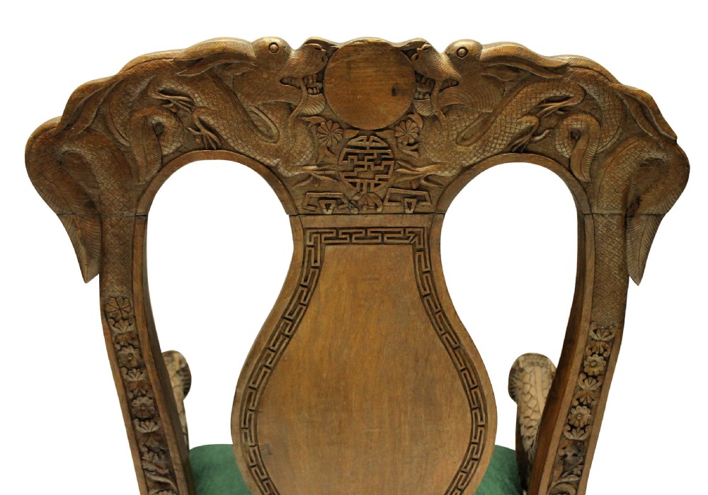 A pair of 19th-century carved teak Chinese armchairs featuring dragon motif armrests, detailed back splats, cabriole legs, and green upholstered seat cushions. View IX