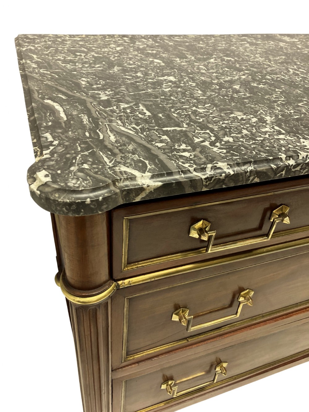 A French Directoire mahogany commode featuring three long drawers with brass mounts, fluted corner pilasters, and a grey marble top. View VI
