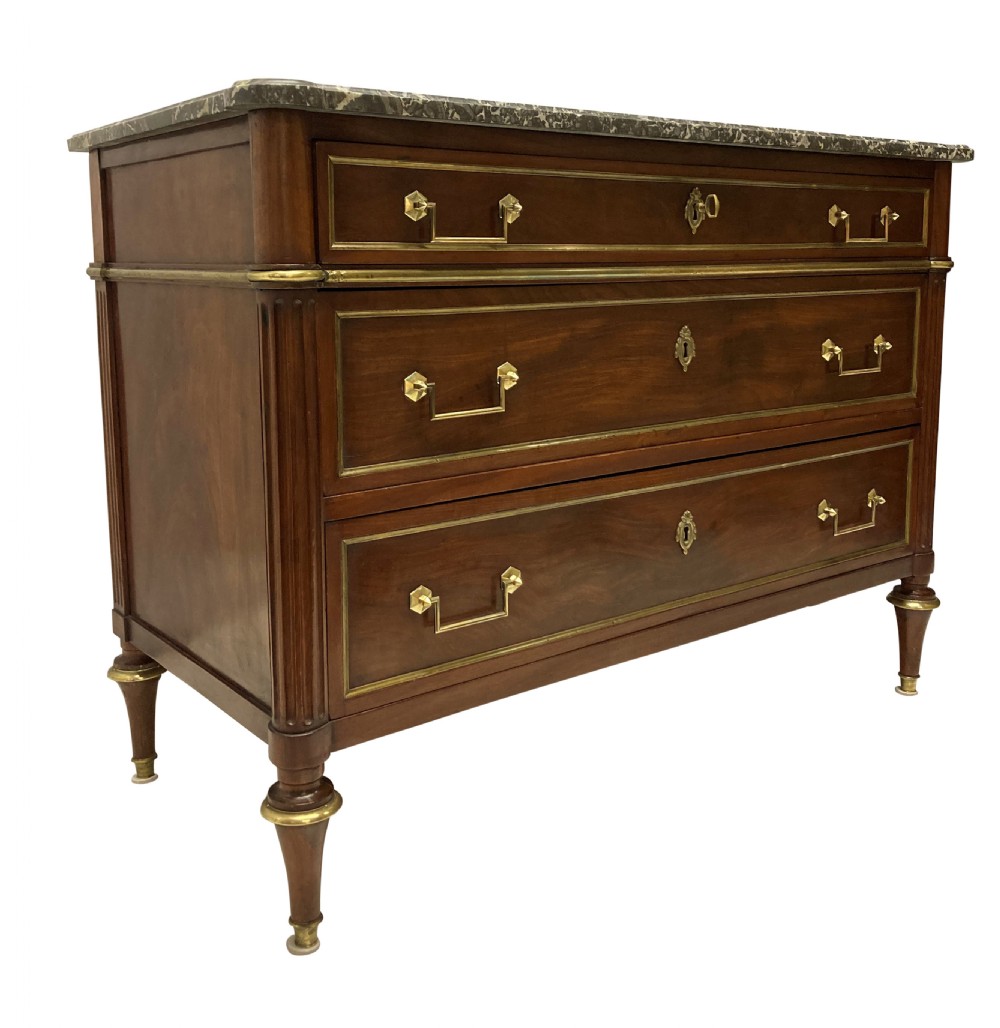 A French Directoire mahogany commode featuring three long drawers with brass mounts, fluted corner pilasters, and a grey marble top. View VII