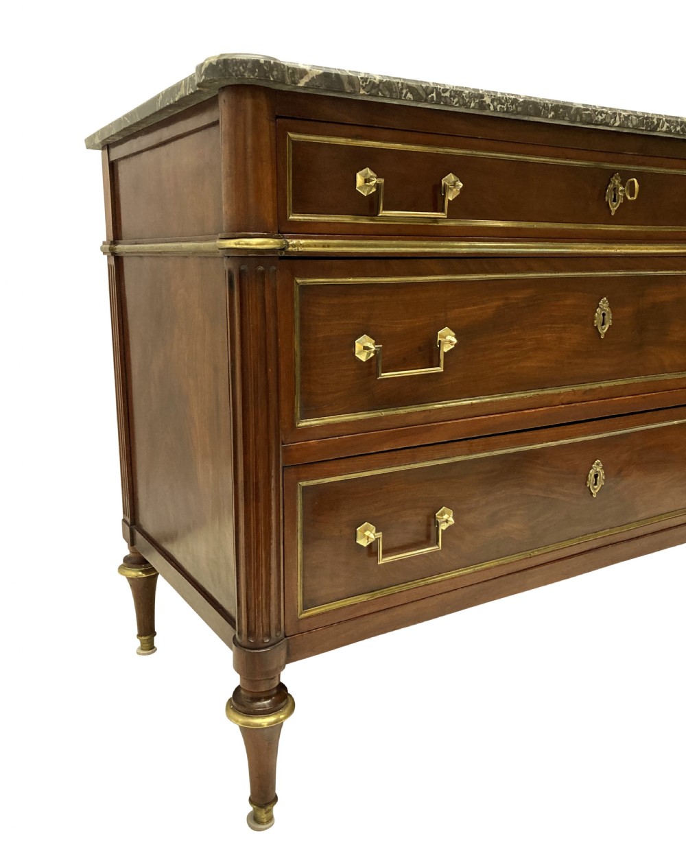 A French Directoire mahogany commode featuring three long drawers with brass mounts, fluted corner pilasters, and a grey marble top. View VIII