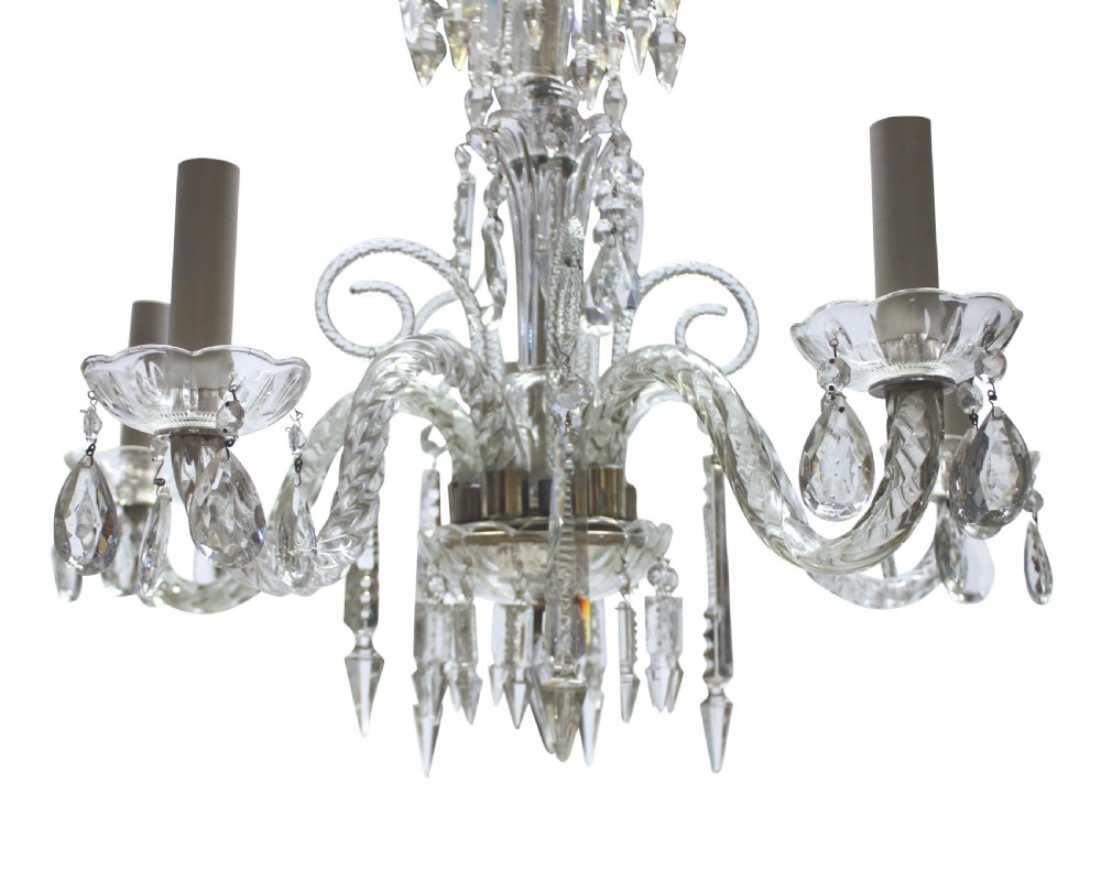 A small clear cut glass chandelier featuring curved glass arms, candle sockets, and faceted crystal drops. View II