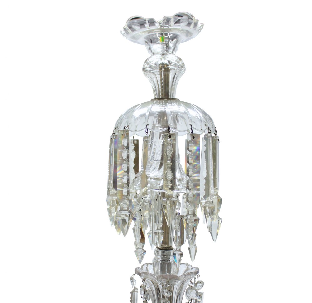 A small clear cut glass chandelier featuring curved glass arms, candle sockets, and faceted crystal drops. View III