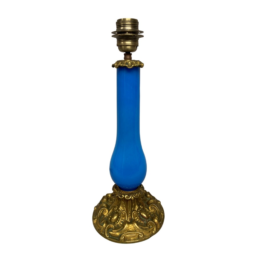 A late 19th-century French table lamp featuring a vibrant blue glass body mounted on a ornate gilt bronze scroll base.