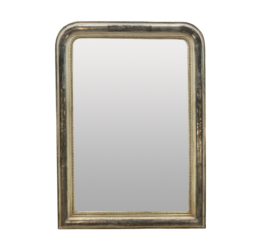 An antique French silver leaf overmantel mirror featuring rounded top corners, a beaded inner rim, and subtle etched leaf motifs on the frame.