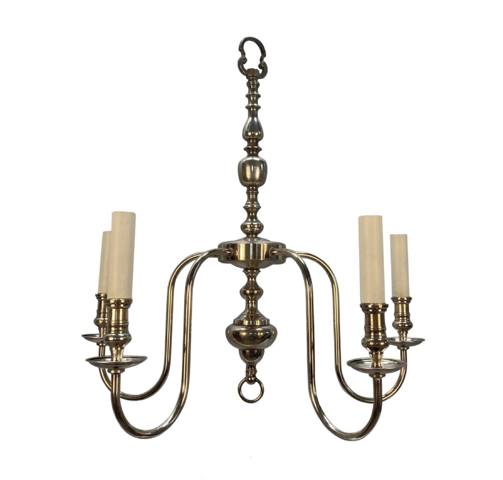 An Edwardian silver-plated five-arm chandelier featuring a turned central baluster column, sweeping curved arms, and candle sleeves.