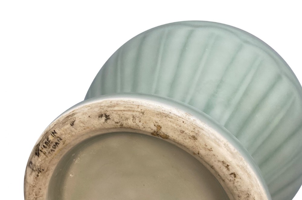 A trio of Japanese ceramic vases featuring a cream crackle-glazed vase, a small turquoise enamel vase with metal mounts, and a tall pale green celadon vase with carved lotus motifs. View VI