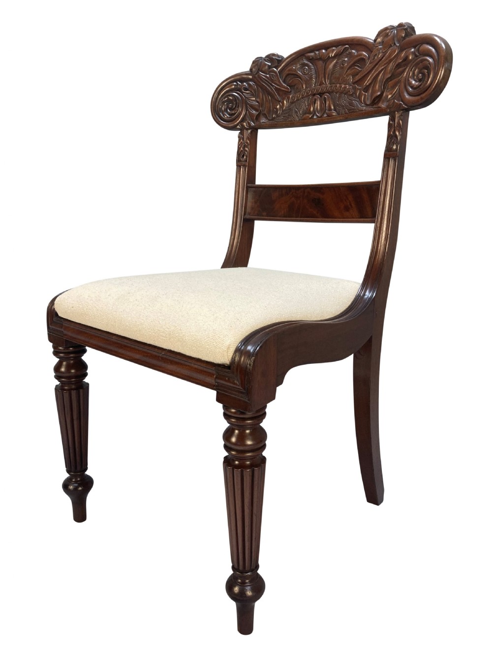 A set of four William IV Anglo-Indian dark wood dining chairs featuring carved scroll top rails, fluted turned front legs, and cream fabric seats. View V