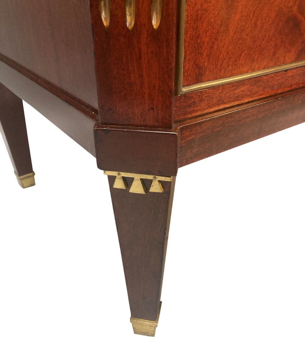 A 19th-century Russian flame mahogany commode featuring three drawers with brass ring handles, fluted corner pilasters, square tapered legs, and a pale green marble top. View VI