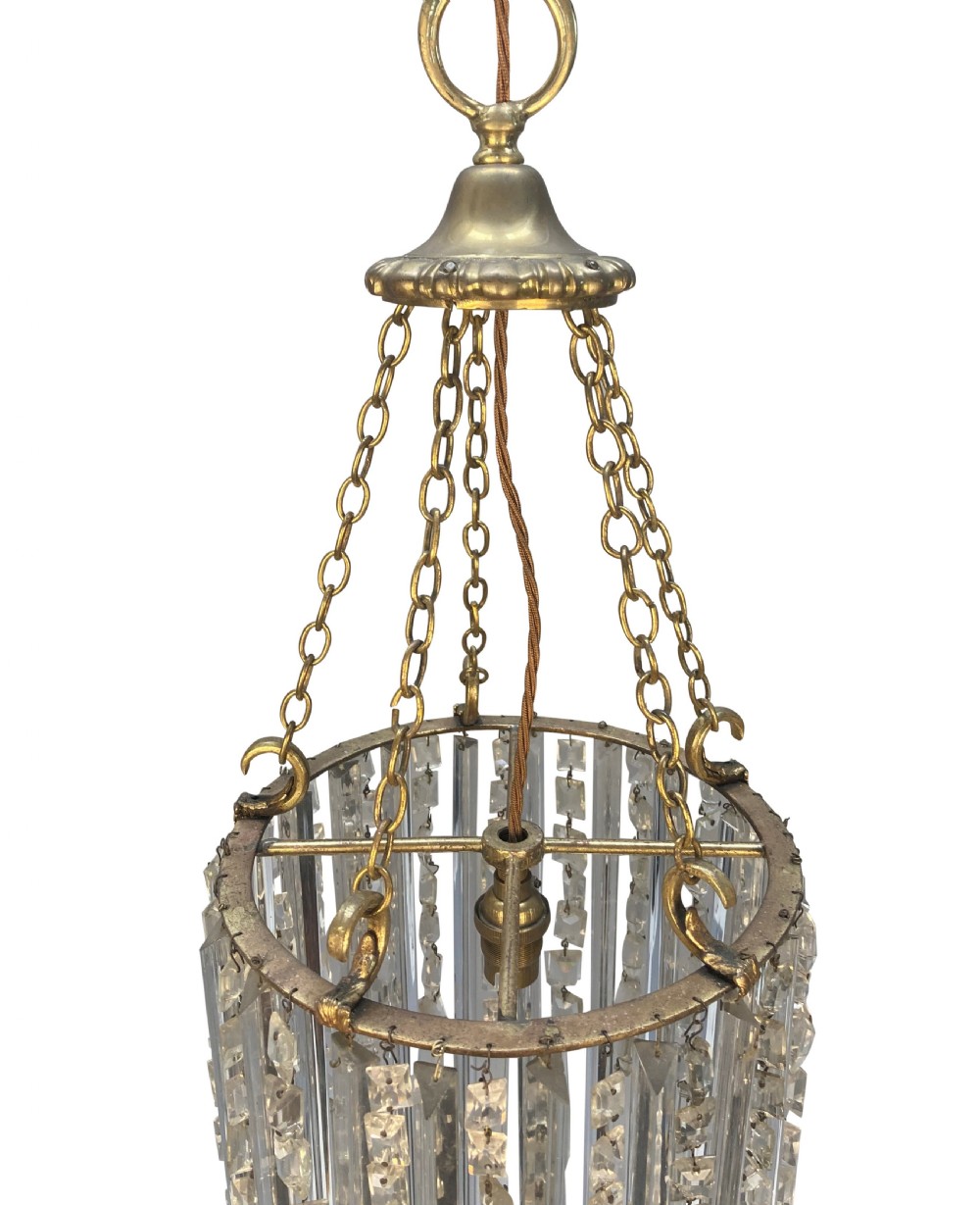 An antique cut glass waterfall pendant light featuring layered clear glass drops suspended from brass chains. View III