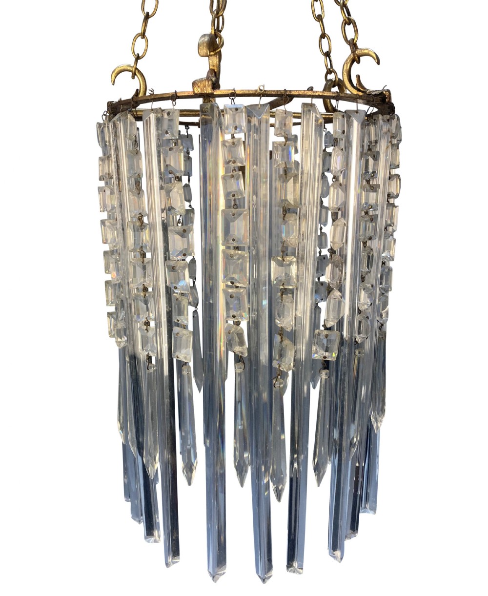 An antique cut glass waterfall pendant light featuring layered clear glass drops suspended from brass chains. View IV