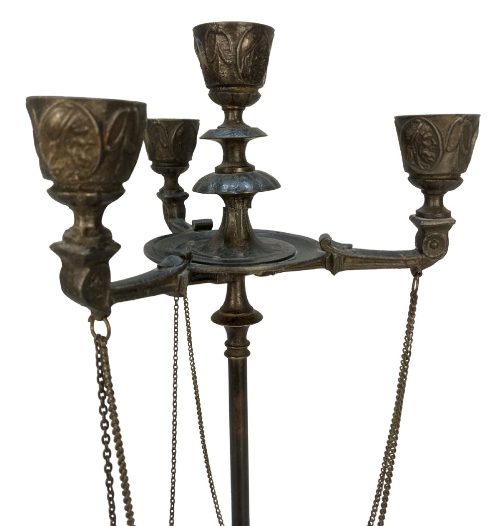 A pair of 19th-century dark bronze three-light candelabra with draped metal chains, classical face masks, and tripod bases ending in claw feet. View V