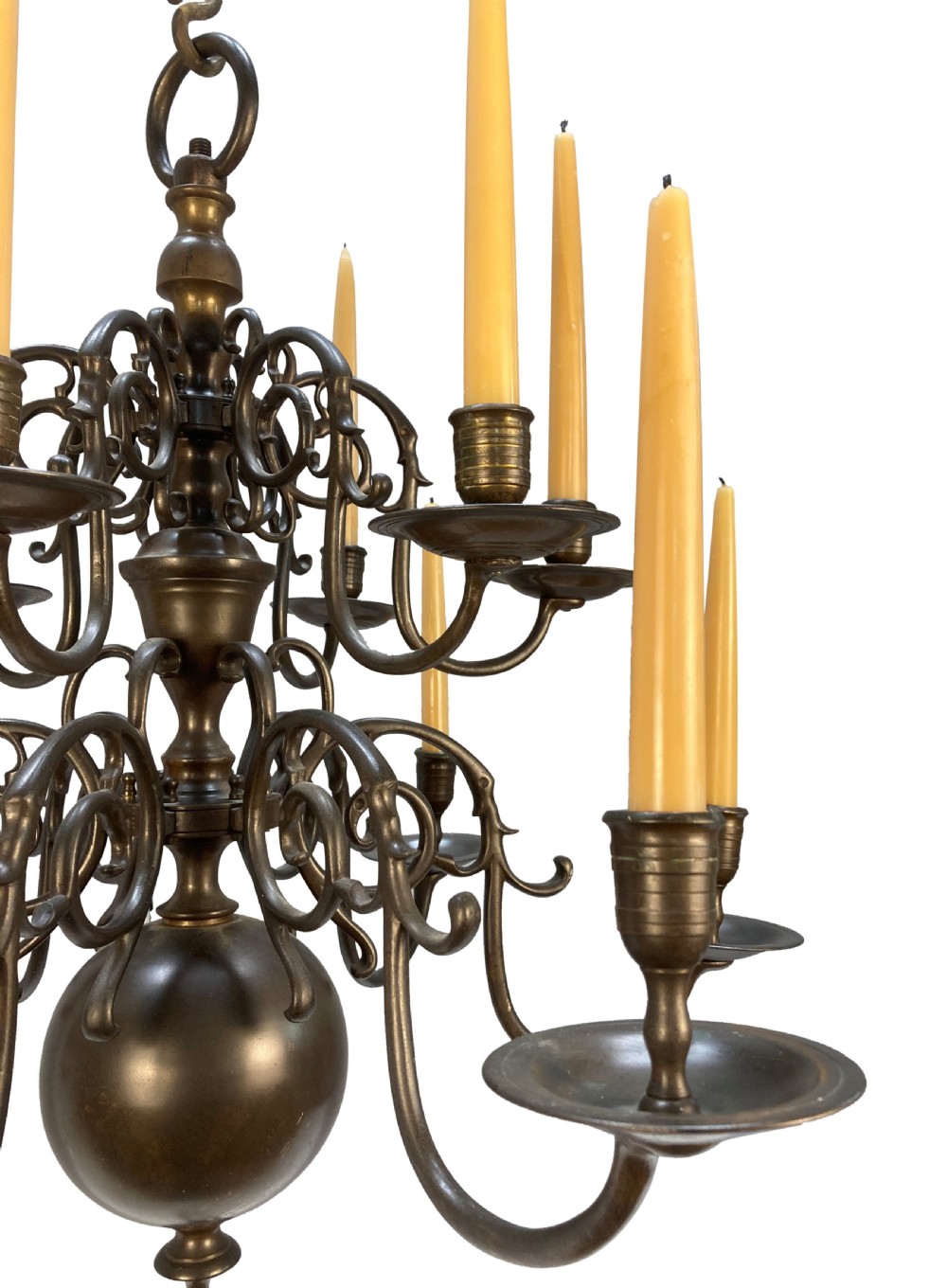 A nineteenth-century multi-tiered bronze chandelier in the Dutch taste featuring scrolling S-curved arms, cylindrical candle nozzles with drip pans, and a central baluster stem terminating in a heavy spherical drop. View III