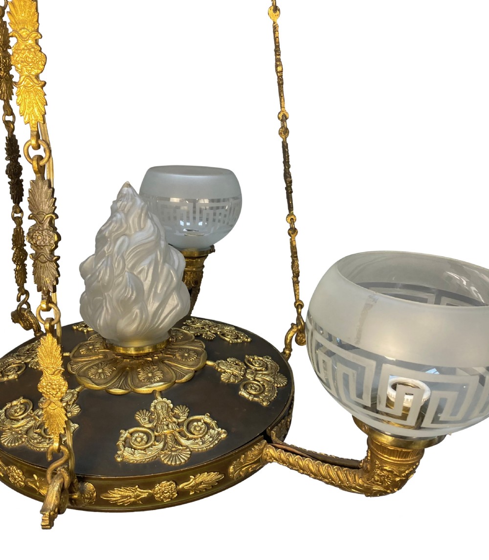 A Regency period gilt and patinated bronze colza hanging light featuring etched frosted glass shades with Greek key motifs. View VI