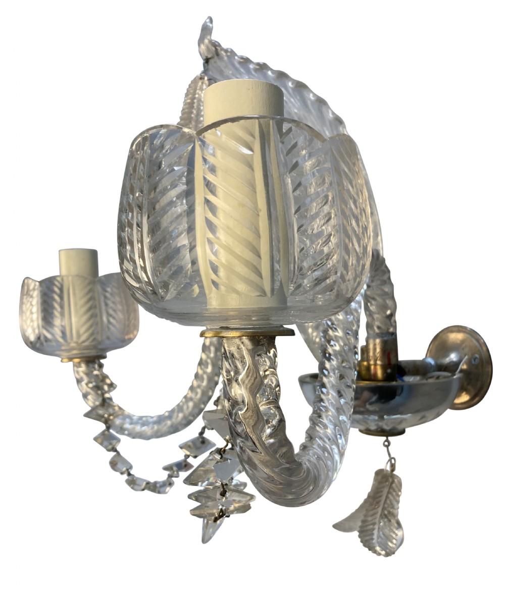 A pair of 1930s Baccarat clear lead crystal twin-branch wall sconces with twisted arms and cut glass candle cups. View II