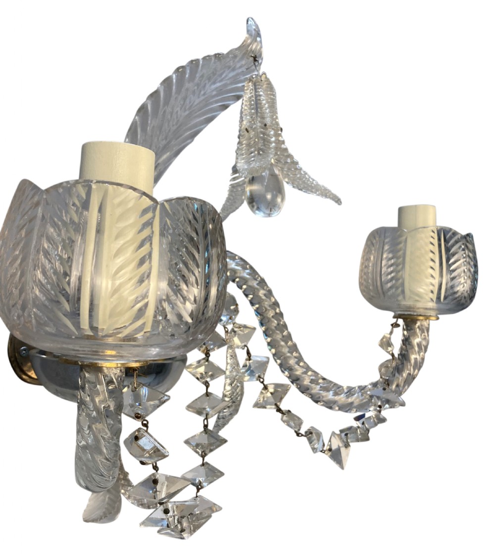 A pair of 1930s Baccarat clear lead crystal twin-branch wall sconces with twisted arms and cut glass candle cups. View VIII