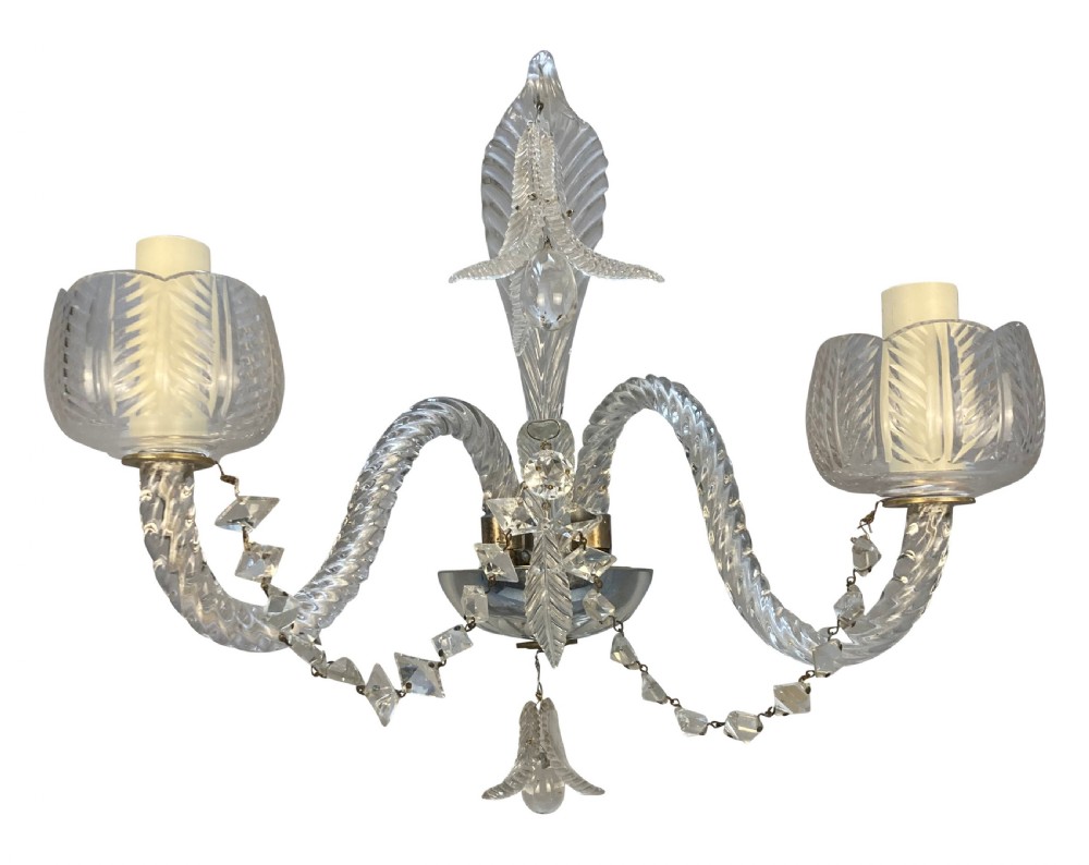 A pair of 1930s Baccarat clear lead crystal twin-branch wall sconces with twisted arms and cut glass candle cups. View IX