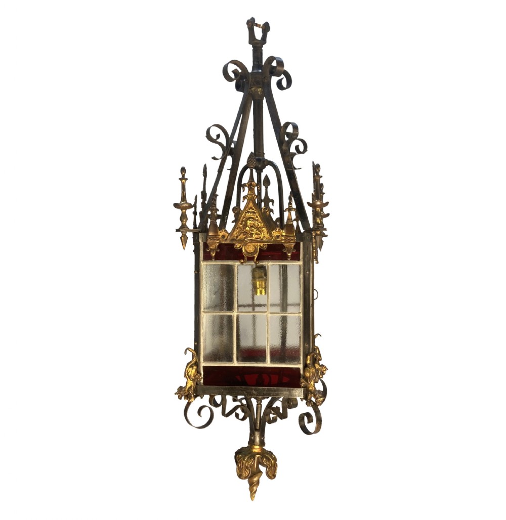 A 19th-century Gothic Revival hanging brass lantern featuring paned glass, ruby red glass borders, ornate crocketed pinnacles, and scrollwork. View II