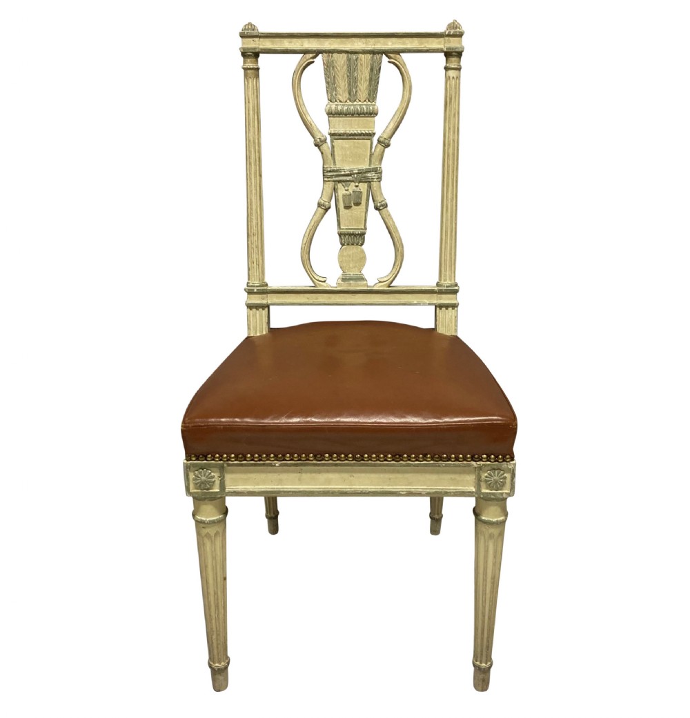 A set of six Louis XVI style cream painted side chairs featuring open carved backs with urn motifs and brown leather upholstered seats with stud detailing. View II
