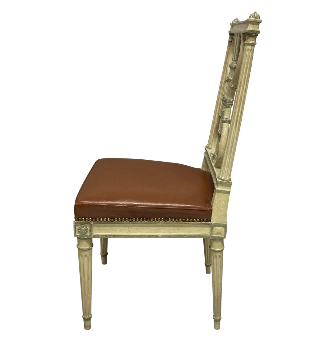 A set of six Louis XVI style cream painted side chairs featuring open carved backs with urn motifs and brown leather upholstered seats with stud detailing. View III