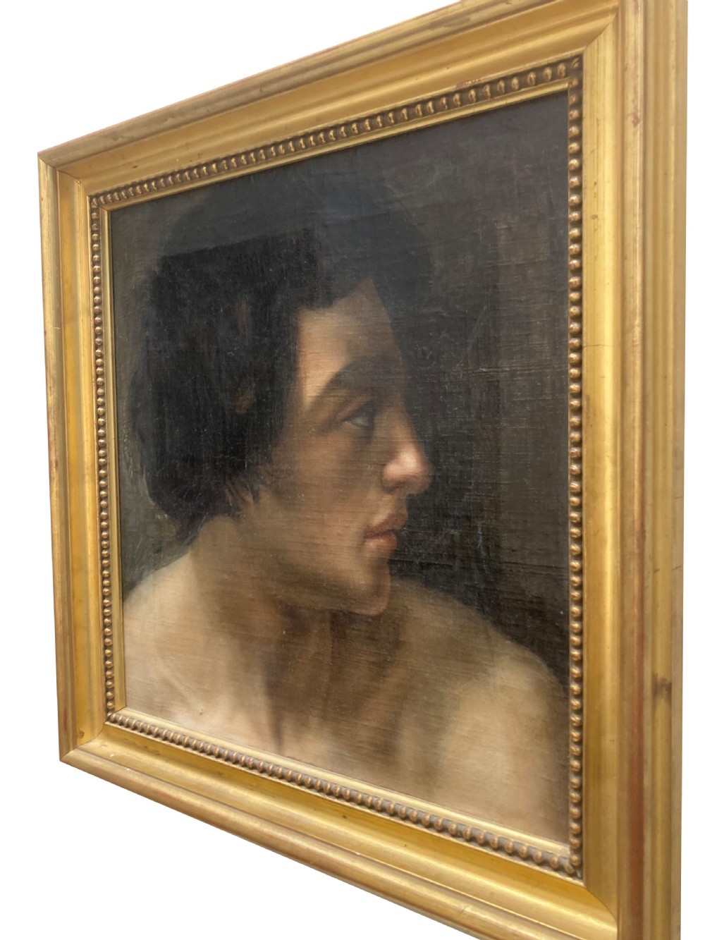 A late seventeenth-century oil portrait painting depicting the profile of a young man with dark curly hair set inside a molded gilt frame. View II