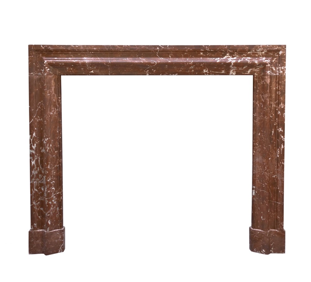 A red and white veined marble fire surround with a convex bolection moulding profile and block plinth bases.