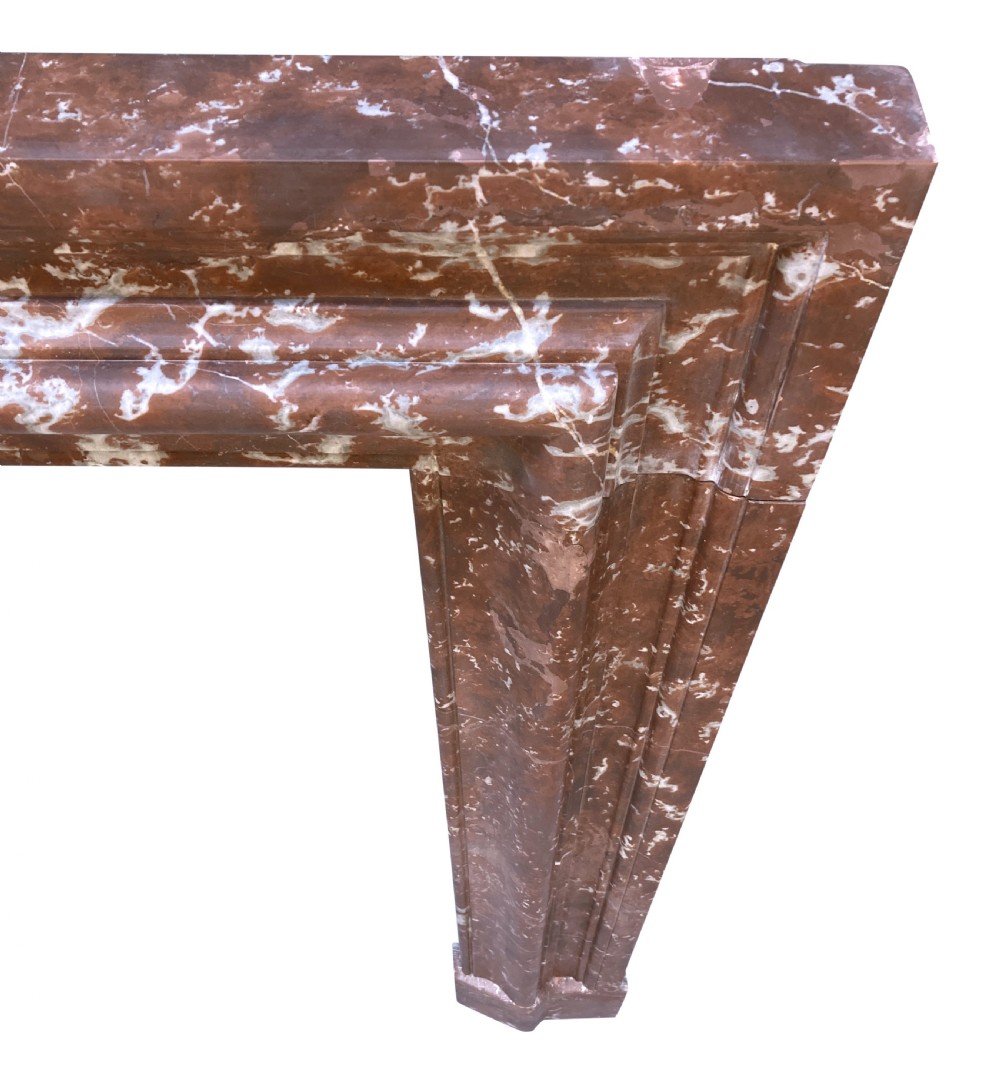 A red and white veined marble fire surround with a convex bolection moulding profile and block plinth bases. View V