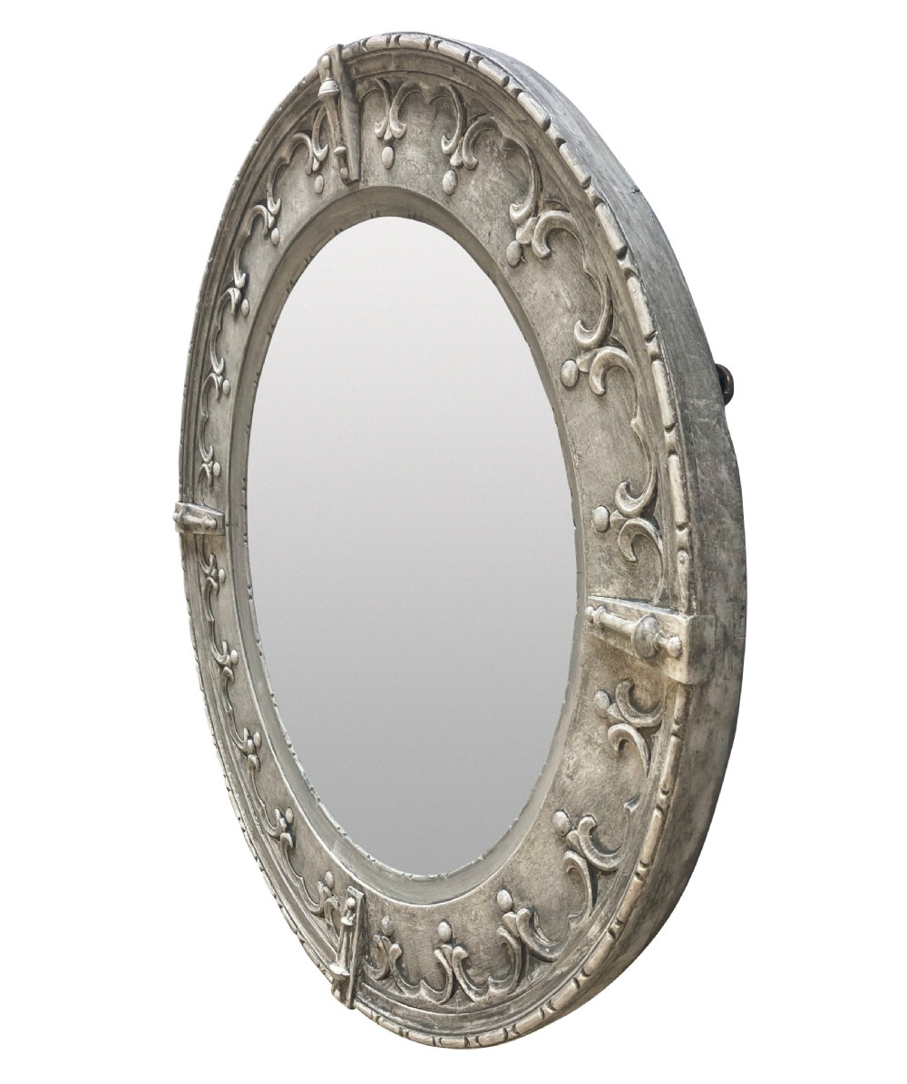 A circular wall mirror featuring a carved oak frame finished in grey gesso with Gothic revival scrolling strapwork and raised cardinal accents. View II