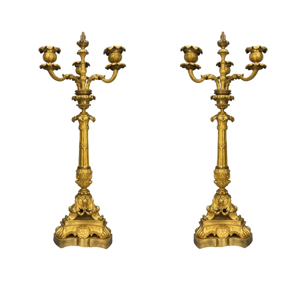 A pair of French Charles X gilt bronze three-light candelabra with scrolling acanthus leaves and fluted columns.